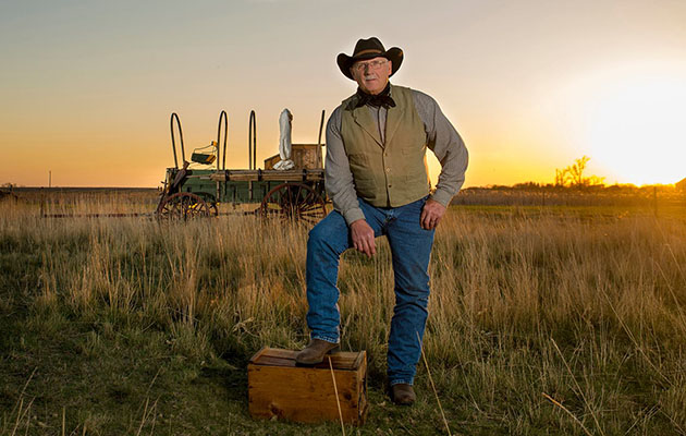Bob Glanzer stands in a field at sunset